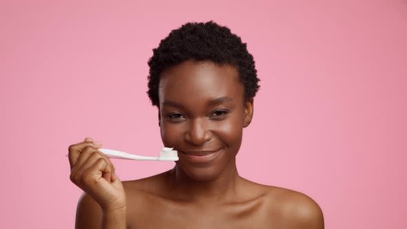 African American Lady Holding Toothbrush With Applied Toothpaste Pink Background