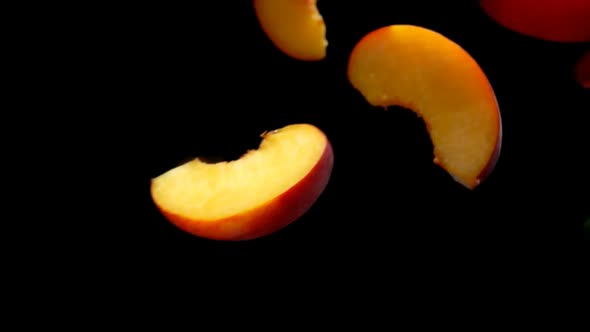 Peach Slices Fly Close-up on a Black Background