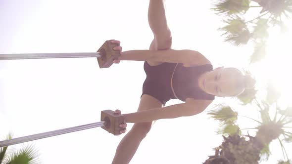 Gymnastics By the Sea a Young Blonde Woman Standing on the Small High Beams with Her Head Upside