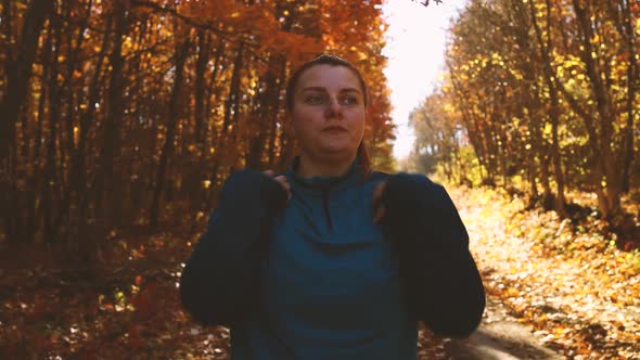 Athlete Runner Stretching Arms Getting Ready for Jogging Workout Along Outdoor in Fall Forest Park