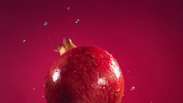 Flying of Pomegranate in Fuchsia Background in Slow Motion