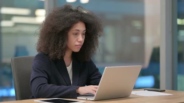 African Businesswoman with Laptop Looking at Camera