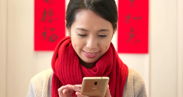 Chinese woman sending blessing message on cellphone during chinese new year