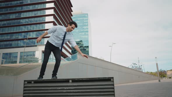 Flexible and cool businessman doing acrobatic tricks outdoor.