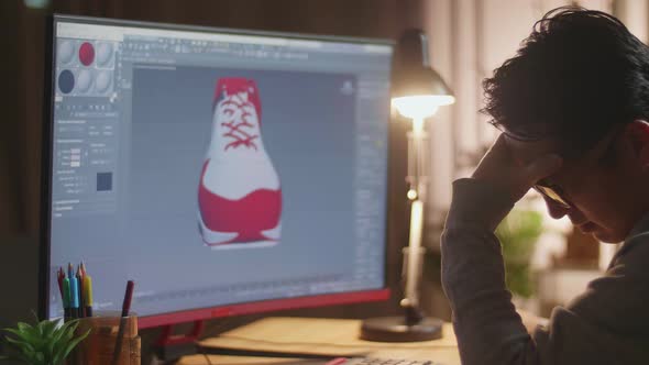 Close Up Of Asian Male Footwear Designer Having A Headache While Designing Shoe On A Desktop At Home