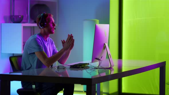 Sad Guy Losing Computer Game in Neon Room