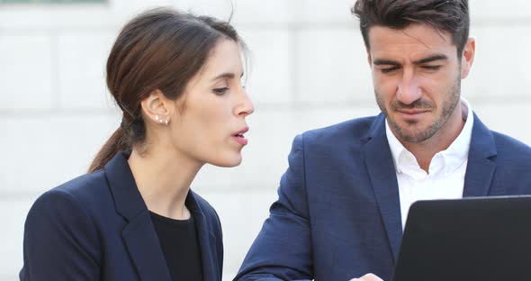 Business People Looking at Laptop Computer and Discuss