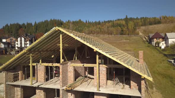 Wooden Frame of New Roof on a Brick Big House Under Construction