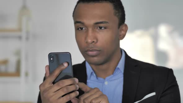 Close Up Of Casual AfroAmerican Businessman Excited for Success While Using Smartphone