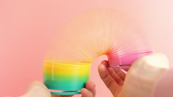 Plastic rainbow toy in hands. Colored spiral for games and tricks popular in the 90s.