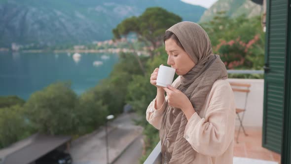 Woman Traditional Arab Dress Stands Terrace Enjoying Drinking Hot Coffee Tea Watching Views of