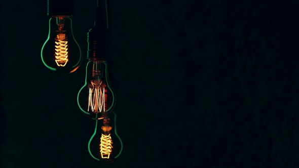 Silhouettes of glowing vintage lamps in the dark copy space.