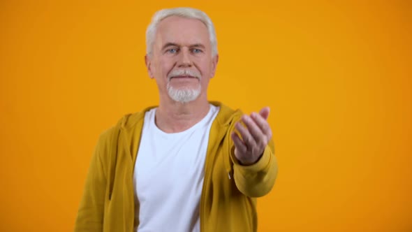 Friendly Male Pensioner Showing Come Here Gesture, Welcoming Person, Invitation