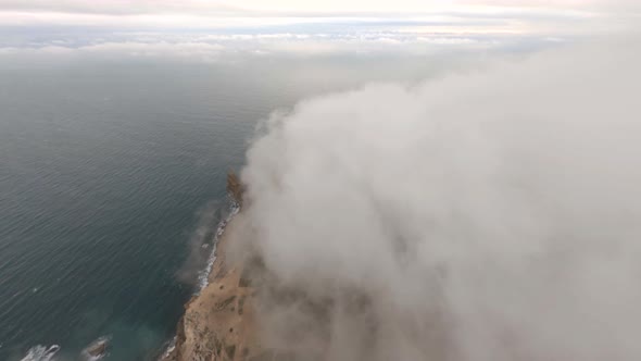 Aerial Shot Flying Over Natural Mountain Fog Over Natural Seascape Scenery with Countryside Village
