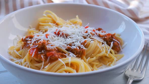 Cooking spaggetti pasta with tomato sauce. Bolognese pasta in white plate.