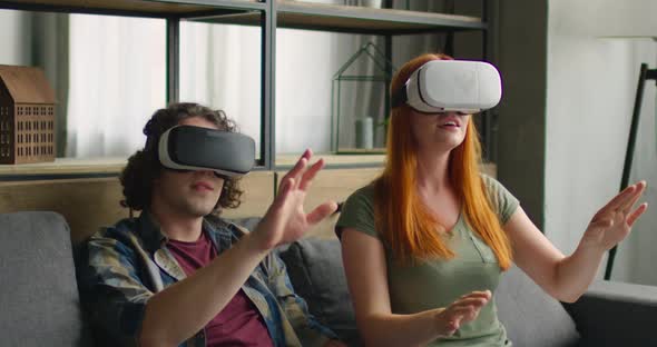 Young Woman and Man Enjoy Their New VR Headsets at Home