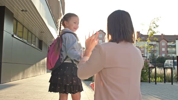 Young Woman Accompanies Her Little Daughter to School