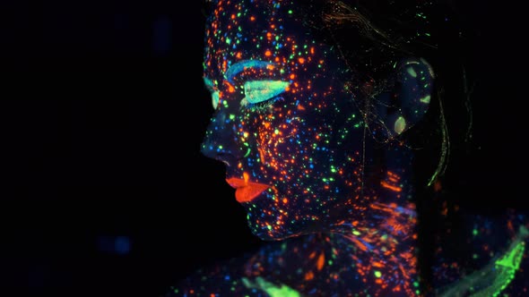 Close-up Portrait in Ultraviolet Light. Face Painted with Glow in the Dark Paint