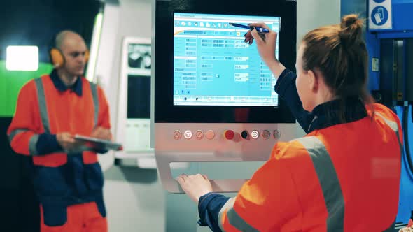 Female Worker Managing Production Process Using Touchscreen