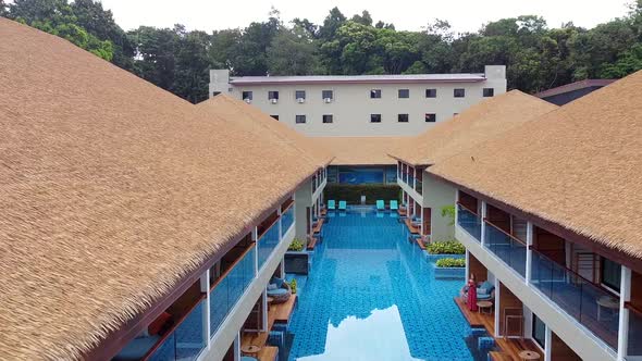 Aerial View Drone Flying Above Swimming Pool and Modern House with Thatched Roof