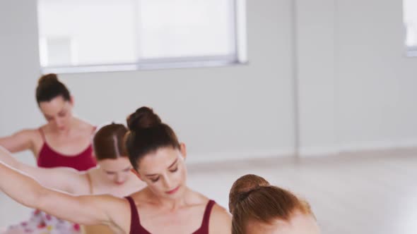 Caucasian ballet female dancers stretching up with a barre before a ballet class