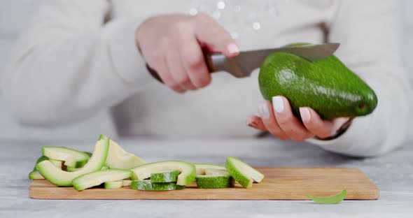 Girl Cuts Open a Fresh Avocado in Half. 