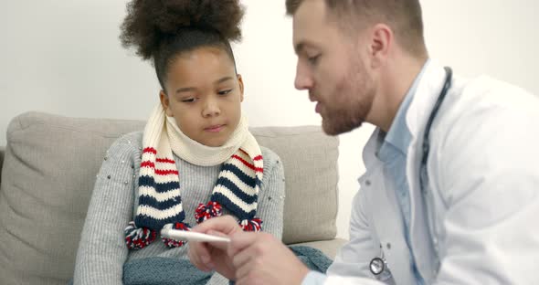 Pediatrician at Home Visiting Helping Little Black Girl