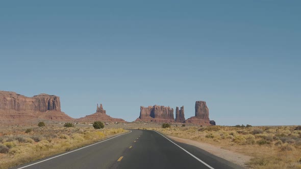 Driving On The Famous Road In Monument Valley Usa Background Of Red Rock Buttes