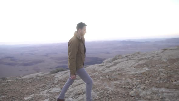 Man walking in the desert with beautiful early morning background