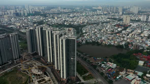 Fly in towards large southeast asian residential high rise housing development with urban sprawl in