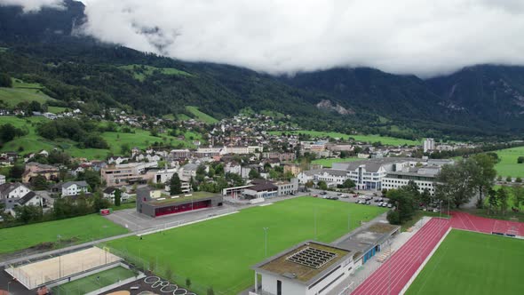 Liechtenstein with Houses on Green Fields in Alps Mountain Valley Aerial View