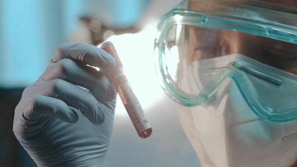 Male Doctor Holds Blood Test Tube To Check a Blood Sample for the COVID-19 Virus