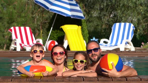 Happy family having fun in swimming pool