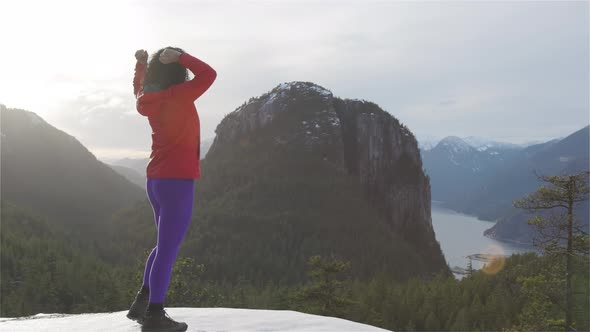 Adventurous Girl Hiking in the Mountains During a Sunny Winter Sunset