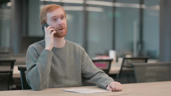 Young Man Talking on Smartphone in Office