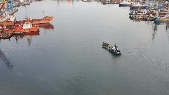 Refueling Vessel is Moving Along the Bay Among Ships Moored to the Quay Walls