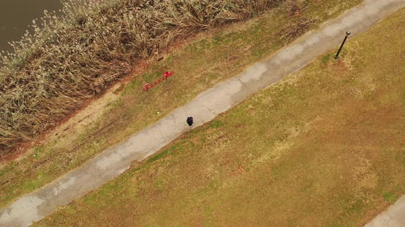 a bird's eye view over a guy walking along a paved walkway on a cloudy day in Flushing Meadows Coron