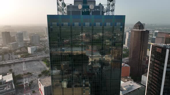 Renaissance Tower in downtown Dallas Texas. Rising aerial reveal during summer sunset. Hazy sky.