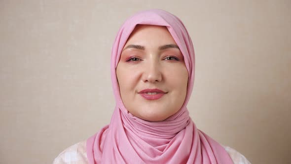 Young Muslim Woman in Pink Headscarf Smiling Looking at Camera