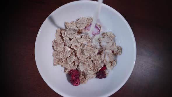 Filling a bowl of cereals with milk in slow motion