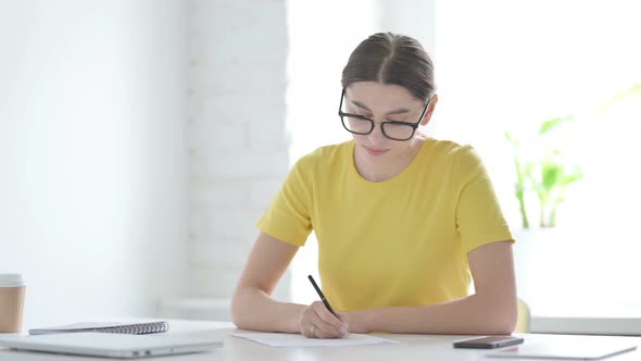 Woman Writing on Paper in Office