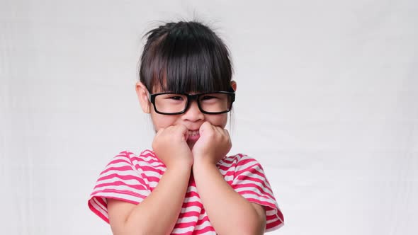 Smiling schoolgirl wearing summer outfit with backpack holding books alt