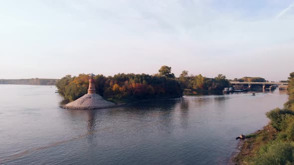 Amazing revealing drone footage of the old stone lighthouse by the Danube river. Beautiful autumn co