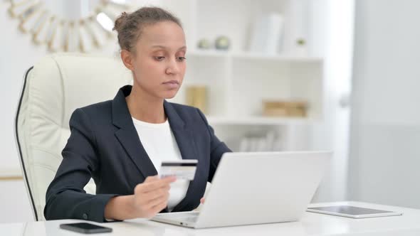 Online Payment Success on Laptop for African Businesswoman in Office 