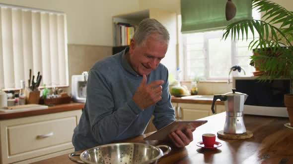 Senior man using digital tablet at home