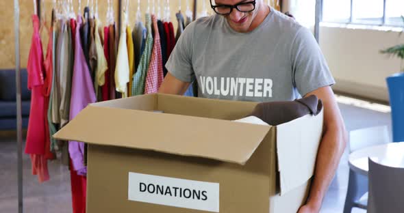 Volunteer holding clothes donation box in office