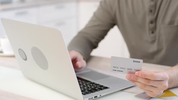 Man Making Online Payment with Credit Card and Laptop