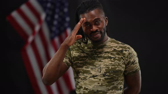 Portrait of Brave Handsome African American Recruit Saluting Posing at Black Background with USA