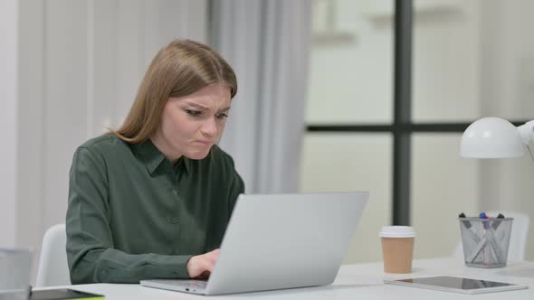 Young Woman Angry While Using Laptop at Work 