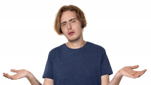 Portrait of Perplexed Man with Brown Hair Shrugging and Gesturing with Both Hands Meaning Oops Sorry